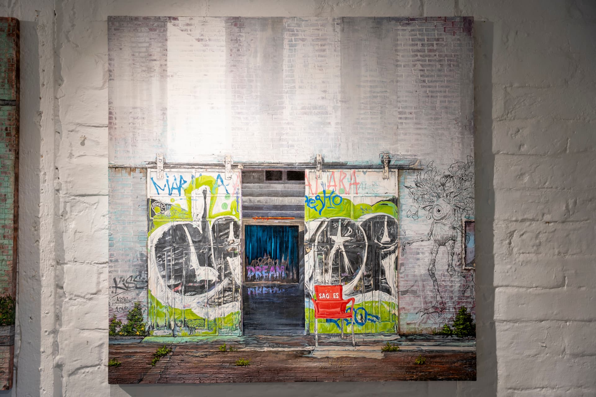 Miranda Donovan's work hanging on a whitewashed brick wall